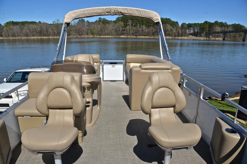 Slide: The Image of 2023 Starcraft EX 18 F pontoon boat with beige seating on a calm lake. - 20
