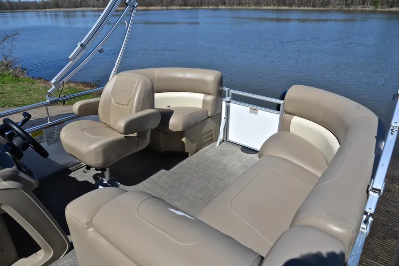 Slide: The Image of 2023 Starcraft EX 18 F pontoon boat interior with beige seating by a lake. - 22