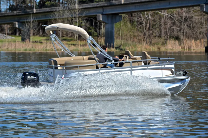 Slide: The Image of 2023 Starcraft EX 18 F pontoon boat cruising on a lake with Suzuki outboard motor. - 5