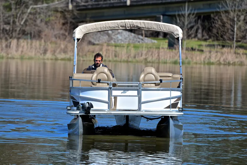 Slide: The Image of 2023 Starcraft EX 18 F pontoon boat on calm water with canopy and seating. - 9