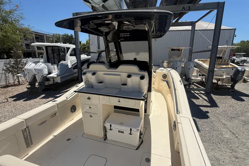 Slide: The Image of 2026 Scout 288 LXF boat interior with seating and storage, docked outdoors. - 10