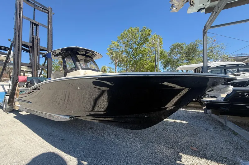 Slide: The Image of 2026 Scout 288 LXF boat on display in a marina under clear blue skies. - 3
