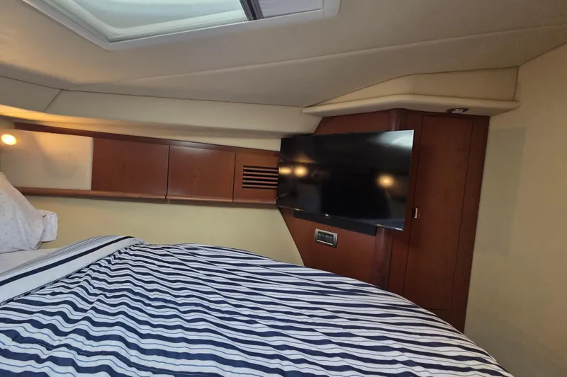 Slide: The Image of Luxurious cabin interior of 2007 Sea Ray 40 Sundancer with striped bedding and mounted TV. - 12