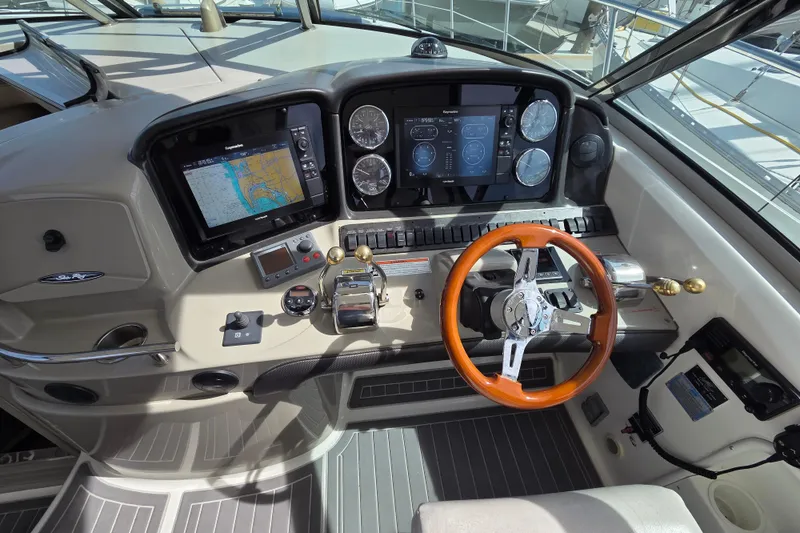 Slide: The Image of 2007 Sea Ray 40 Sundancer helm with navigation screens and wooden steering wheel. - 18