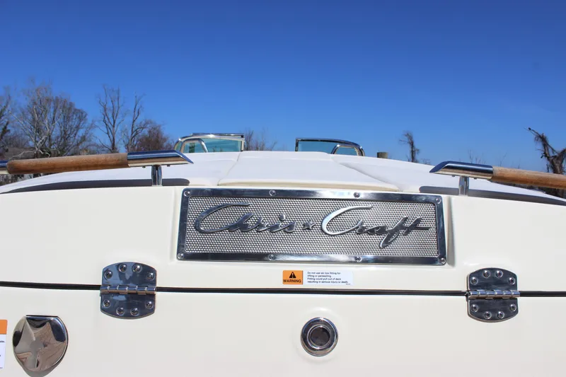 Slide: The Image of 2024 Chris-Craft Launch 27 boat rear view with logo and blue sky background. - 10