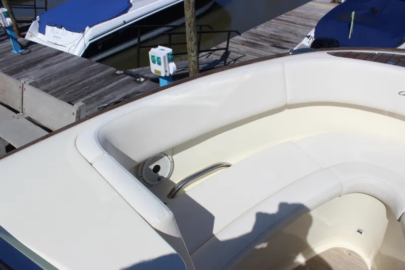 Slide: The Image of 2024 Chris-Craft Launch 27 boat interior with white seating at a dock. - 12