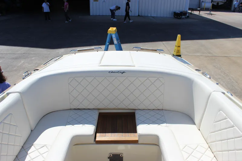 Slide: The Image of 2024 Chris-Craft Launch 27 boat interior with white quilted seating and wooden accents. - 15