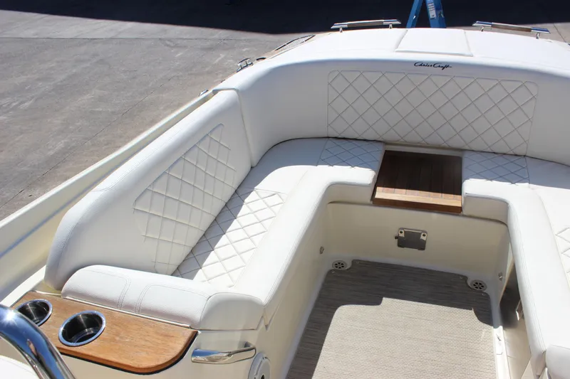 Slide: The Image of 2024 Chris-Craft Launch 27 boat interior with white quilted seating and wooden accents. - 19