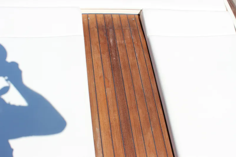 Slide: The Image of 2024 Chris-Craft Launch 27 boat deck with wooden finish and white seating. - 20