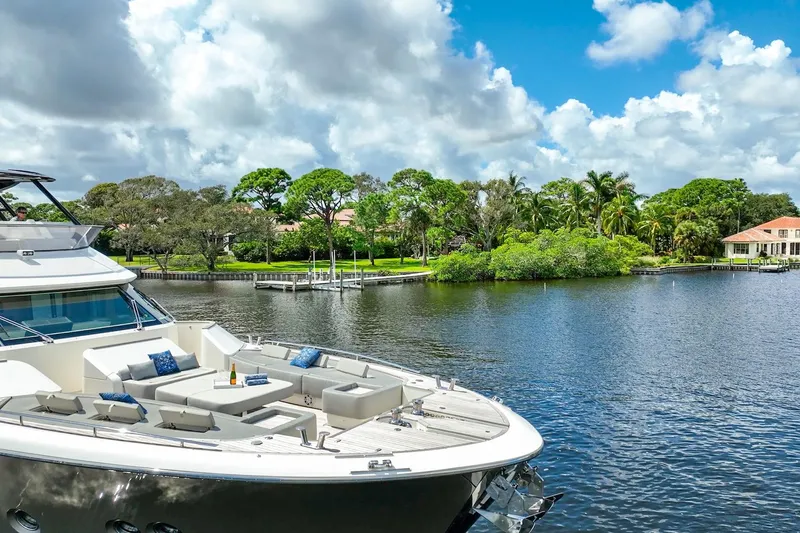Slide: The Image of Luxurious 2015 Monte Carlo Yachts MCY 86 on scenic waterfront with lush greenery. - 12