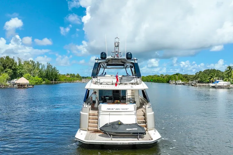 Slide: The Image of 2015 Monte Carlo Yachts MCY 86 on a serene waterway under a bright blue sky. - 18