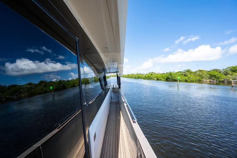 Slide: The Image of 2015 Monte Carlo Yachts MCY 86 cruising on a serene river under a clear blue sky. - 23