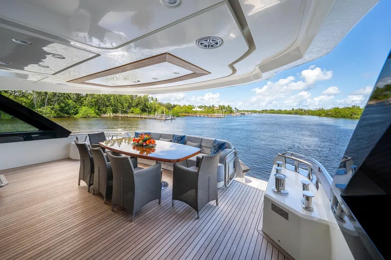 Slide: The Image of Luxurious 2015 Monte Carlo Yachts MCY 86 deck with elegant dining area and scenic water view. - 50