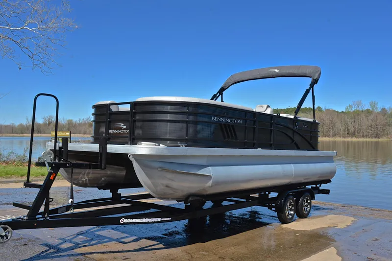 Slide: The Image of 2022 Bennington 22 L pontoon boat on trailer by a lake. - 10