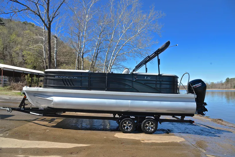 Slide: The Image of 2022 Bennington 22 L pontoon boat on trailer by a lake. - 11