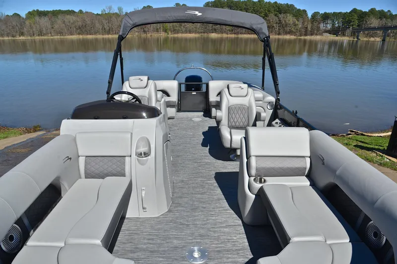 Slide: The Image of 2022 Bennington 22 L pontoon boat with luxurious seating on a serene lake. - 20