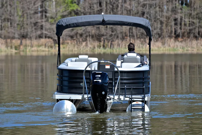 Slide: The Image of 2022 Bennington 22 L pontoon boat on a calm lake, rear view. - 7