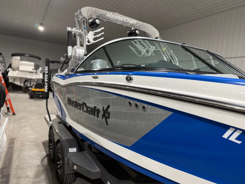 Slide: The Image of 2016 MasterCraft X20 boat in a garage, blue and white design. - 10