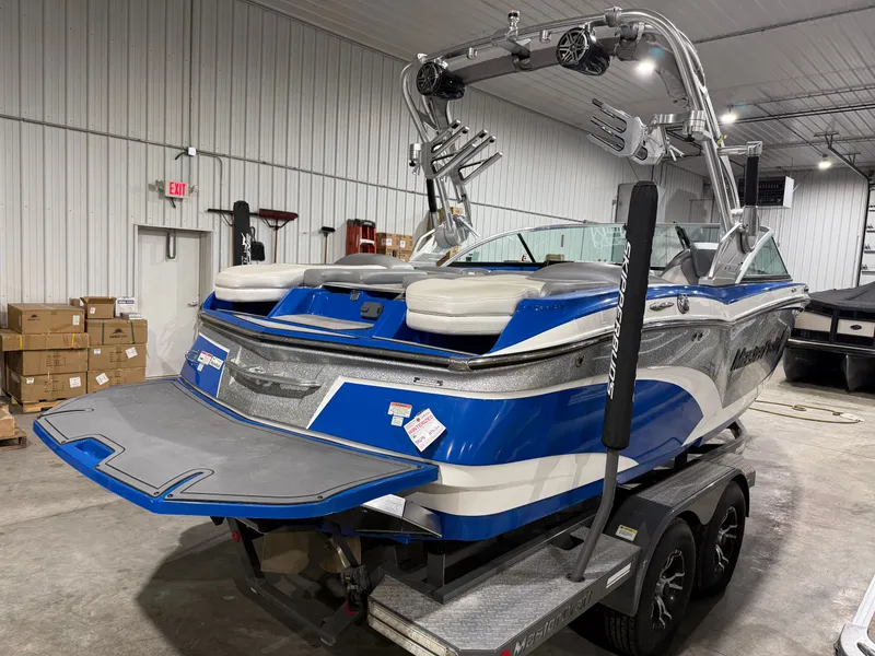Slide: The Image of 2016 MasterCraft X20 boat in warehouse, blue and white design. - 16