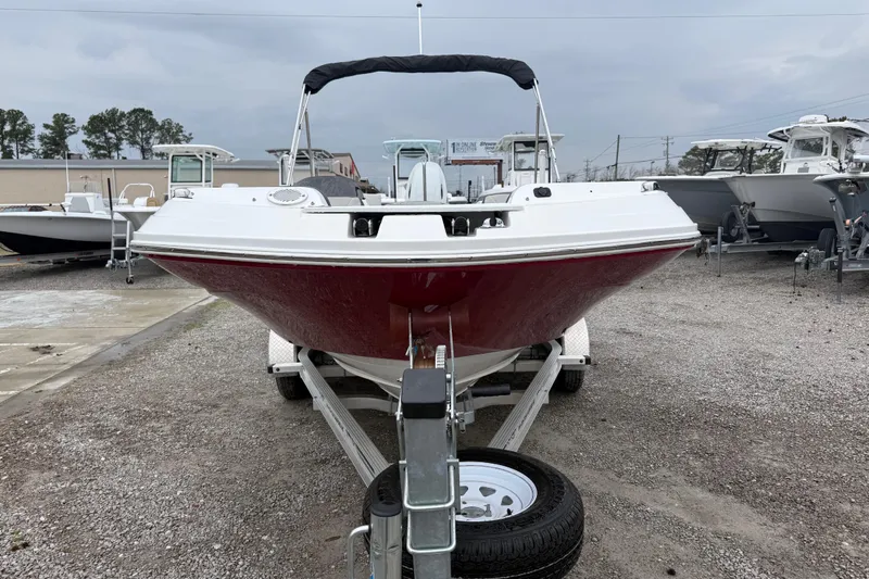 Slide: The Image of 2022 Hurricane SunDeck Sport 205 OB boat on trailer, front view, overcast sky. - 13