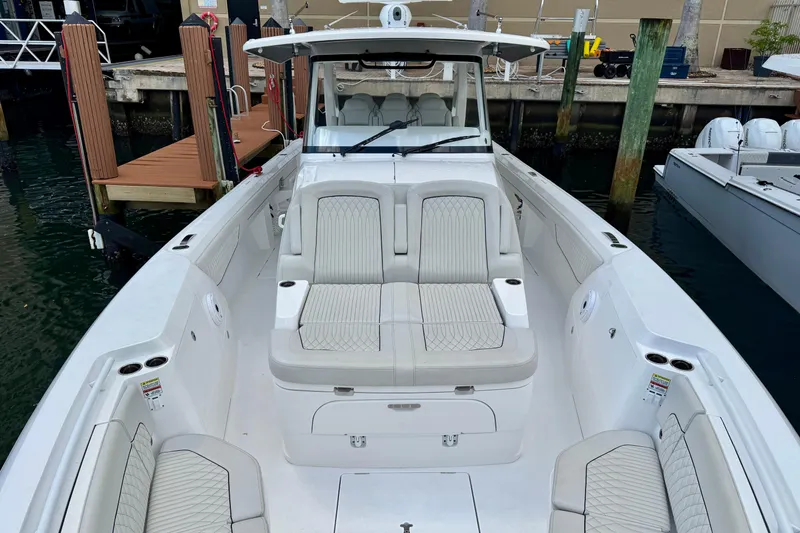 Slide: The Image of 2024 Intrepid 427 Nomad SE boat with spacious seating and sleek design at dock. - 2