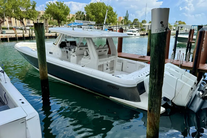 Slide: The Image of 2024 Intrepid 427 Nomad SE boat docked in marina, featuring sleek design and powerful engines. - 35
