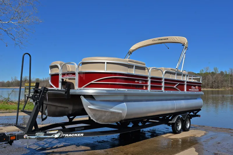 Slide: The Image of 2019 Sun Tracker SportFish 22 DLX pontoon boat on trailer by a lake. - 10