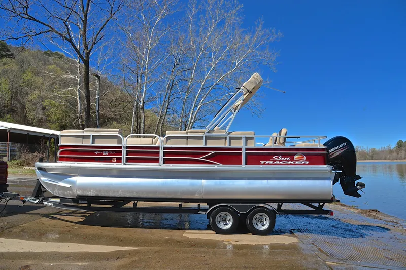 Slide: The Image of 2019 Sun Tracker SportFish 22 DLX pontoon boat on trailer by a lake. - 11