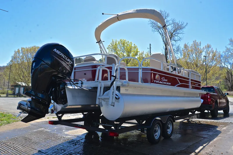 Slide: The Image of 2019 Sun Tracker SportFish 22 DLX pontoon boat on trailer, parked outdoors. - 14