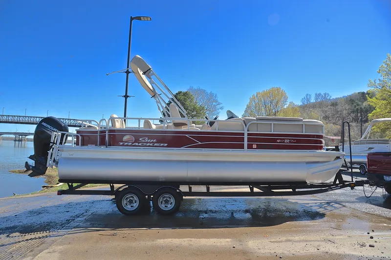 Slide: The Image of 2019 Sun Tracker SportFish 22 DLX pontoon boat on trailer by riverside. - 15