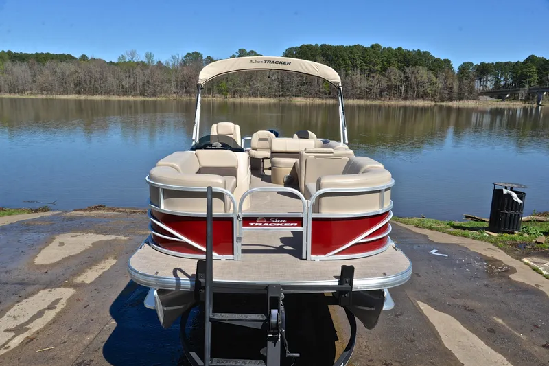 Slide: The Image of 2019 Sun Tracker SportFish 22 DLX pontoon boat by a serene lake. - 17