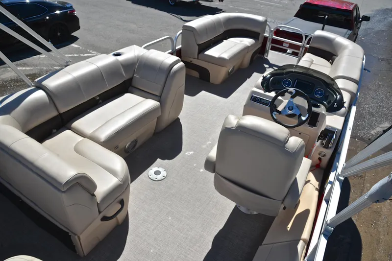 Slide: The Image of 2019 Sun Tracker SportFish 22 DLX pontoon boat interior with beige seating and steering console. - 19
