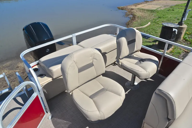 Slide: The Image of 2019 Sun Tracker SportFish 22 DLX boat interior with beige seating near water. - 23