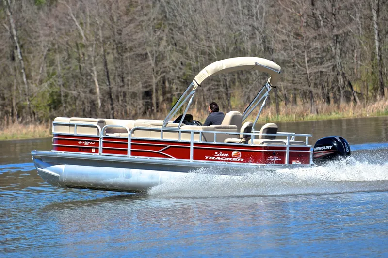 Slide: The Image of 2019 Sun Tracker SportFish 22 DLX pontoon boat cruising on a lake. - 4