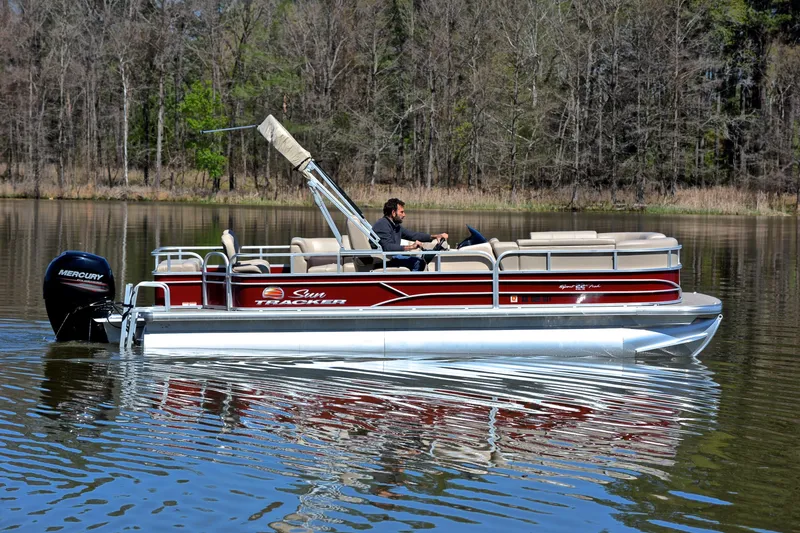 Slide: The Image of 2019 Sun Tracker SportFish 22 DLX pontoon boat cruising on a calm lake. - 6