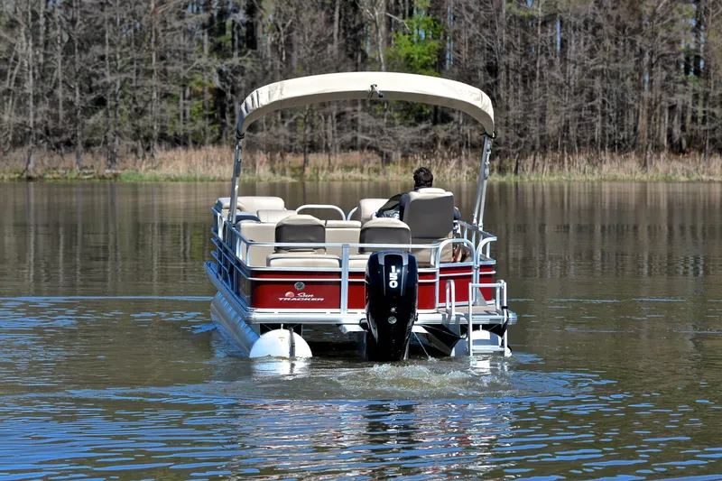 Slide: The Image of 2019 Sun Tracker SportFish 22 DLX pontoon boat cruising on a calm lake. - 7