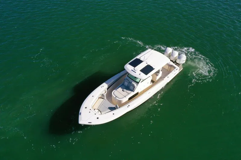 Slide: The Image of 2021 Scout 355 LXF boat cruising on clear green water. - 10