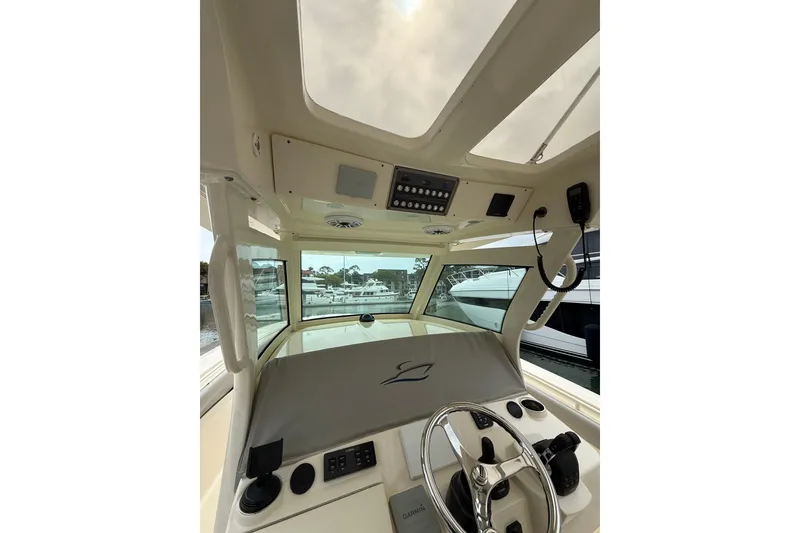 Slide: The Image of 2021 Scout 355 LXF boat helm with steering wheel and control panel. - 11