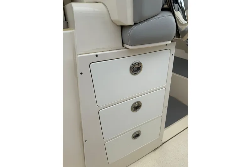 Slide: The Image of 2021 Scout 355 LXF boat interior with three white storage drawers. - 16