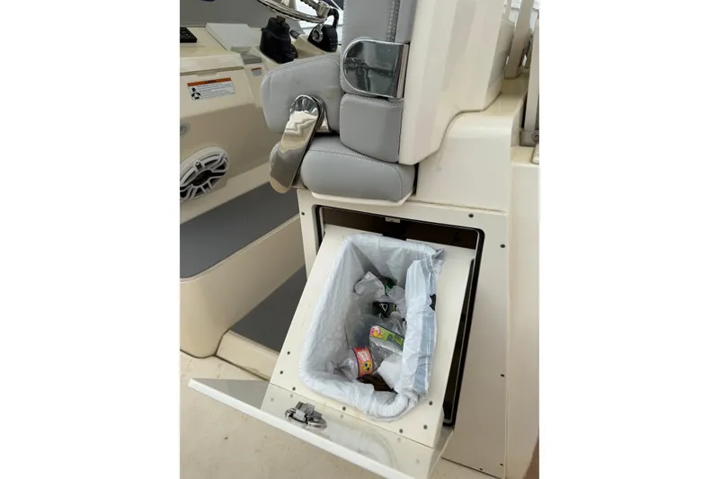 Slide: The Image of 2021 Scout 355 LXF boat interior with built-in trash compartment. - 17