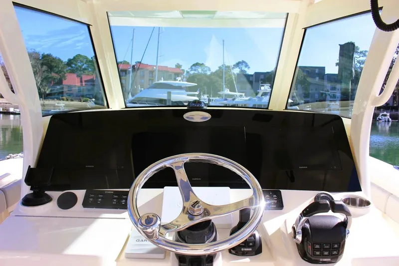 Slide: The Image of 2021 Scout 355 LXF boat helm with steering wheel and navigation controls. - 5