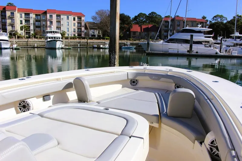 Slide: The Image of 2021 Scout 355 LXF boat docked in a marina with luxury yachts. - 7