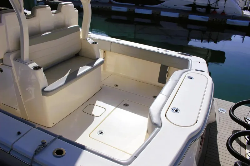 Slide: The Image of 2021 Scout 355 LXF boat interior with seating and storage, docked at marina. - 9