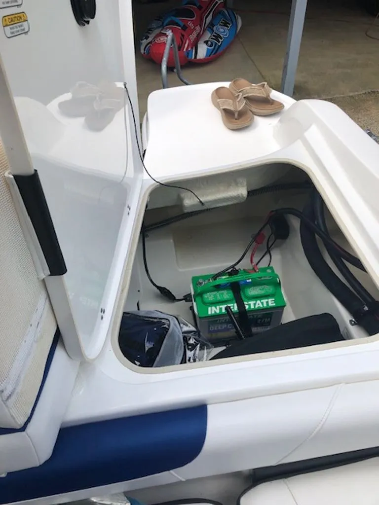 Slide: The Image of Open battery compartment of 2024 Tahoe 185 S boat with shoes on top. - 17