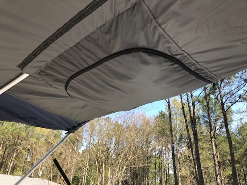 Slide: The Image of 2024 Tahoe 185 S boat canopy in a forest setting. - 21