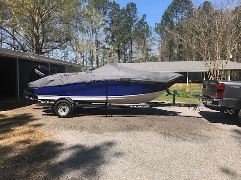 Slide: The Image of 2024 Tahoe 185 S boat on trailer, covered, parked outdoors. - 24