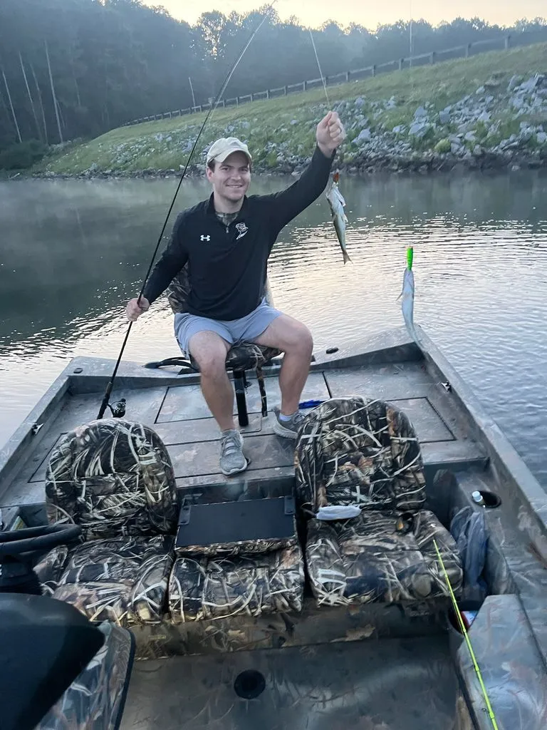 Slide: The Image of Angler on Triton 17 C TX boat holding a caught fish. - 21