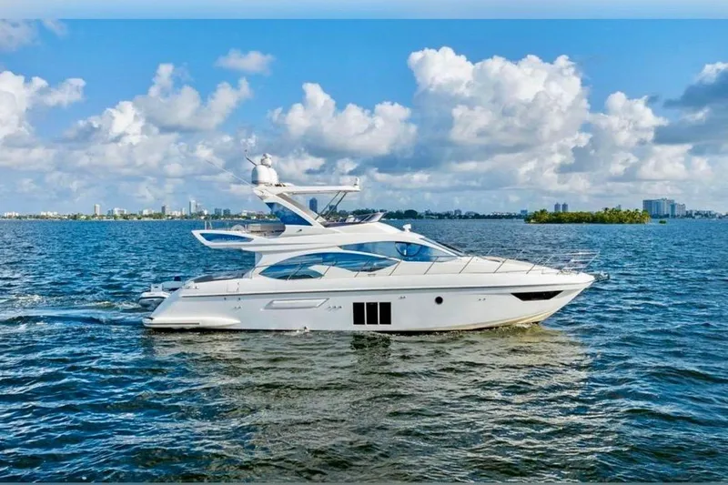 The Image of Luxury 2016 Azimut 54 yacht cruising on a sunny day with city skyline backdrop. - 1