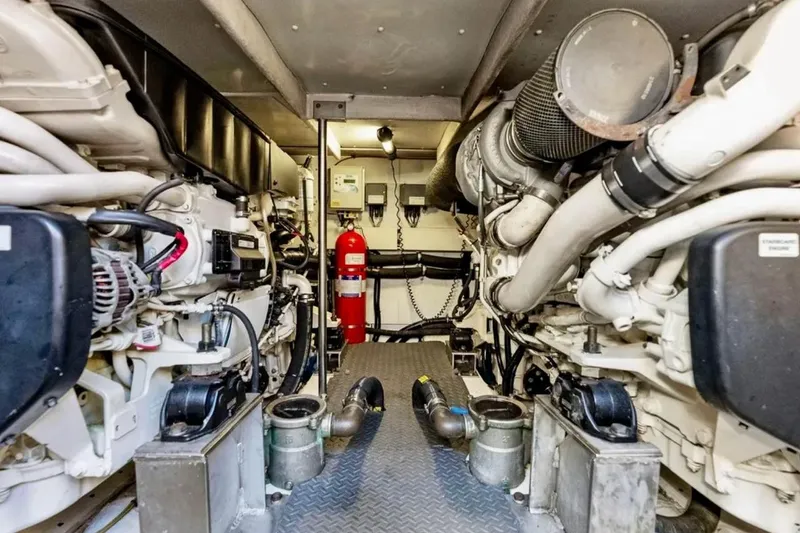 Slide: The Image of Engine room of a 2016 Azimut 54 yacht, showcasing mechanical components and fire extinguisher. - 57