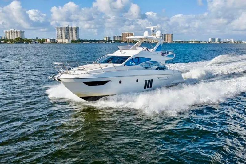 Slide: The Image of Luxury 2016 Azimut 54 yacht cruising on open water under a clear blue sky. - 9